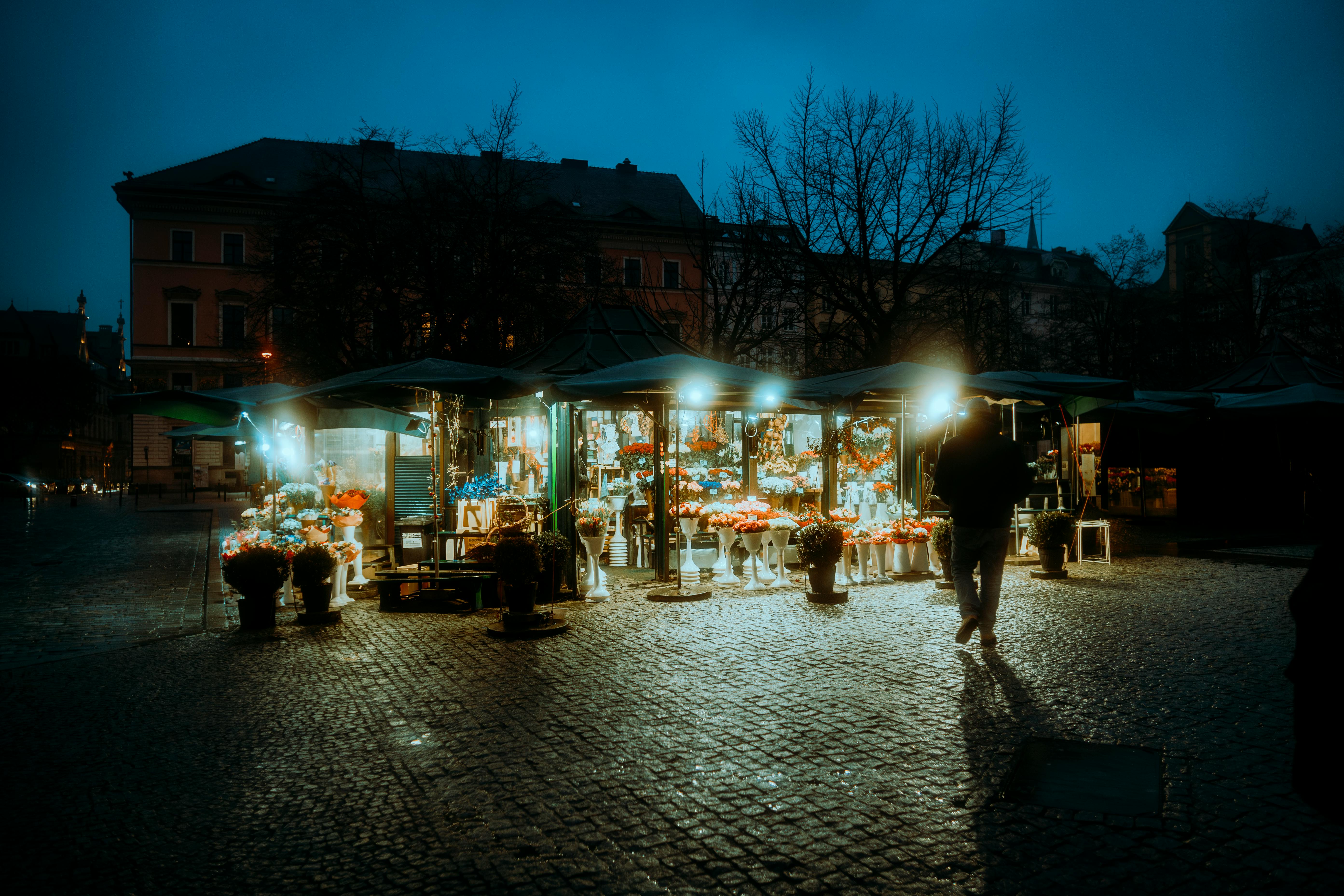 무료 폴란드 브레슬라우의 환하게 불 밝혀진 꽃 시장이 해질녘에 생동감 넘치는 색감과 신비로운 분위기 속에 포착되었습니다. 스톡 사진