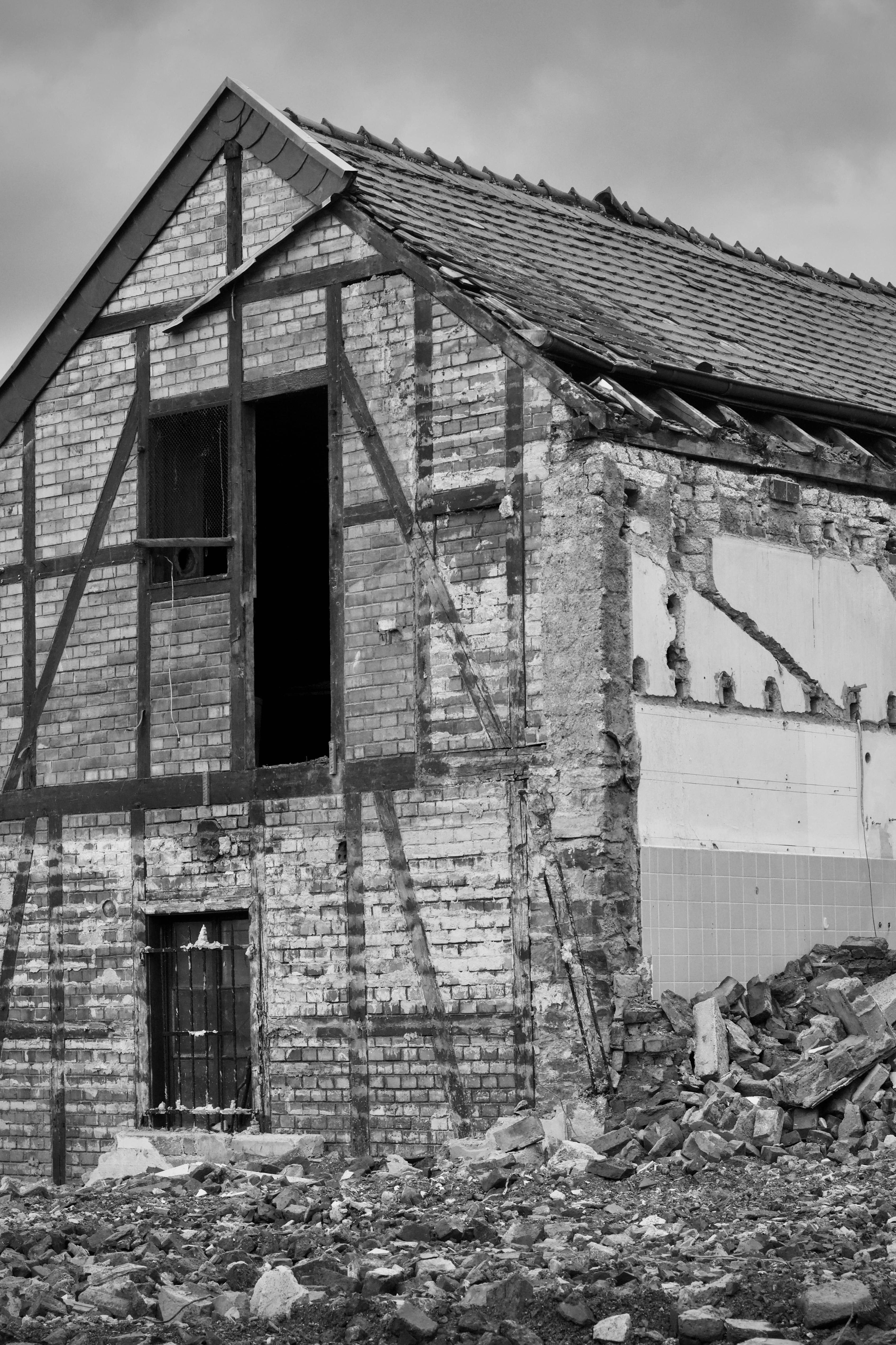 Gratis Immagine monocromatica di un edificio in mattoni parzialmente demolito. Foto a disposizione