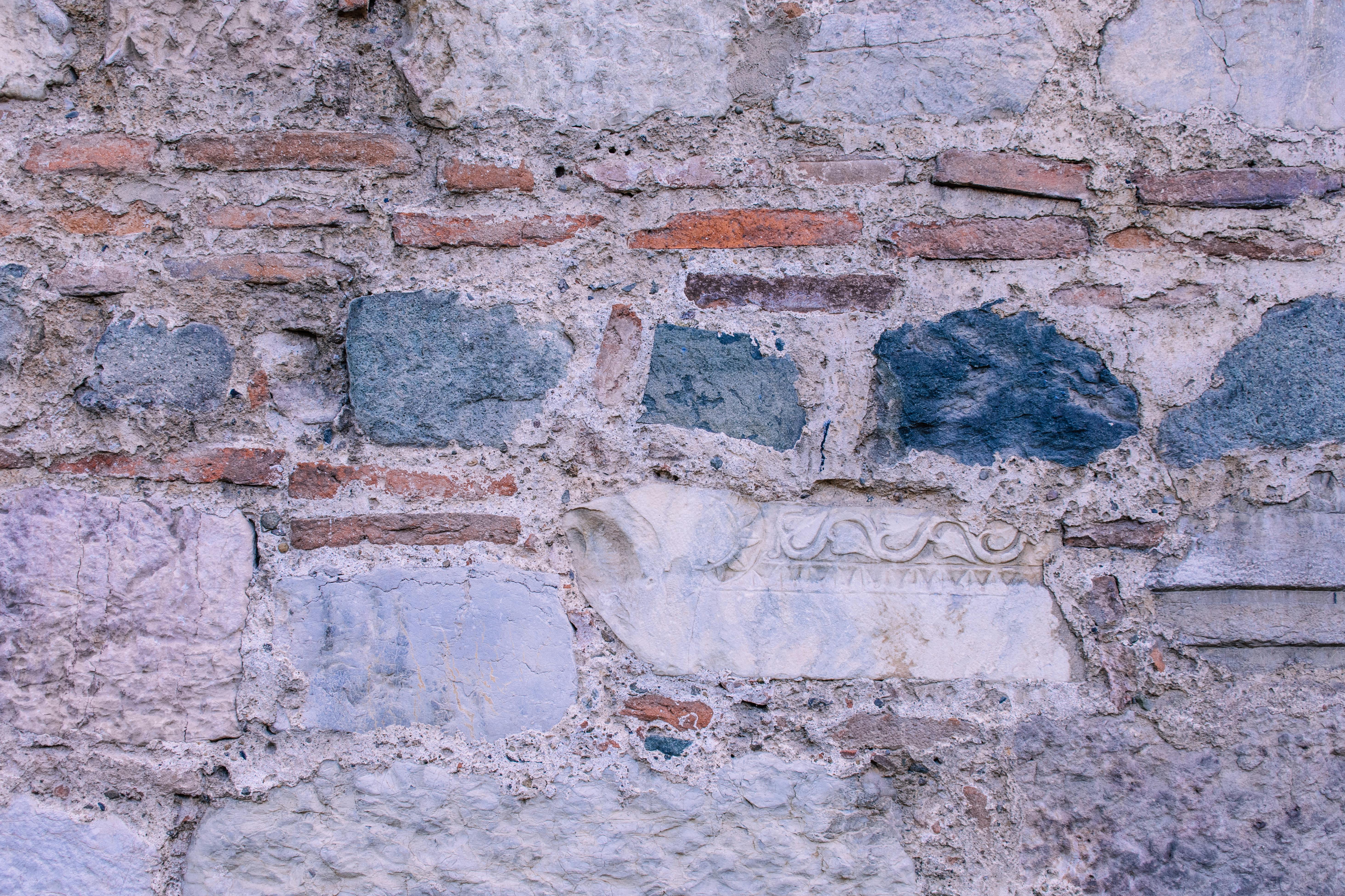 bezplatná Detailní záběr na omšelou kamennou a cihlovou zeď s texturou a vzorem. Základová fotografie