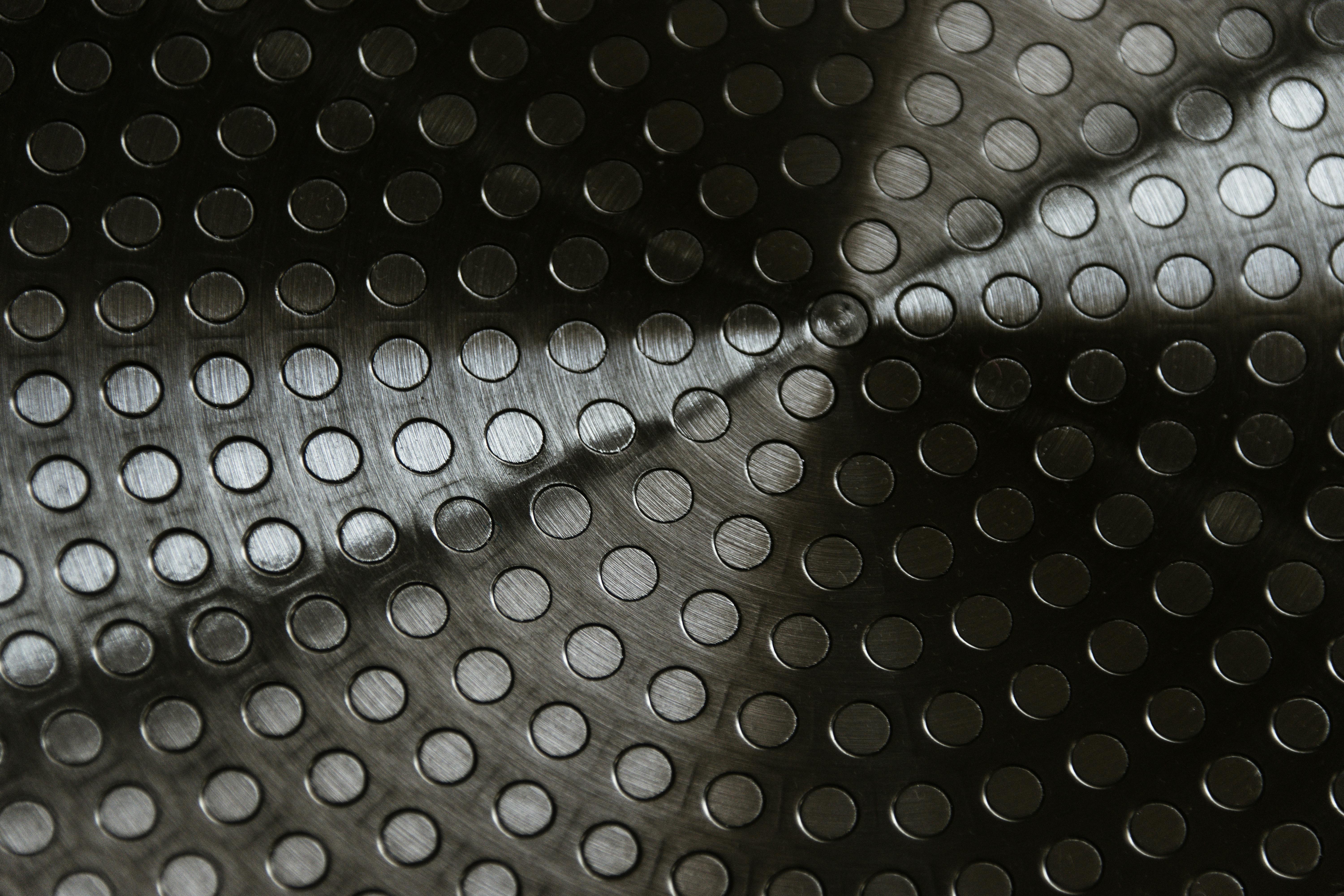 Free Close-up of a metallic surface with circular patterns creating an abstract texture. Stock Photo