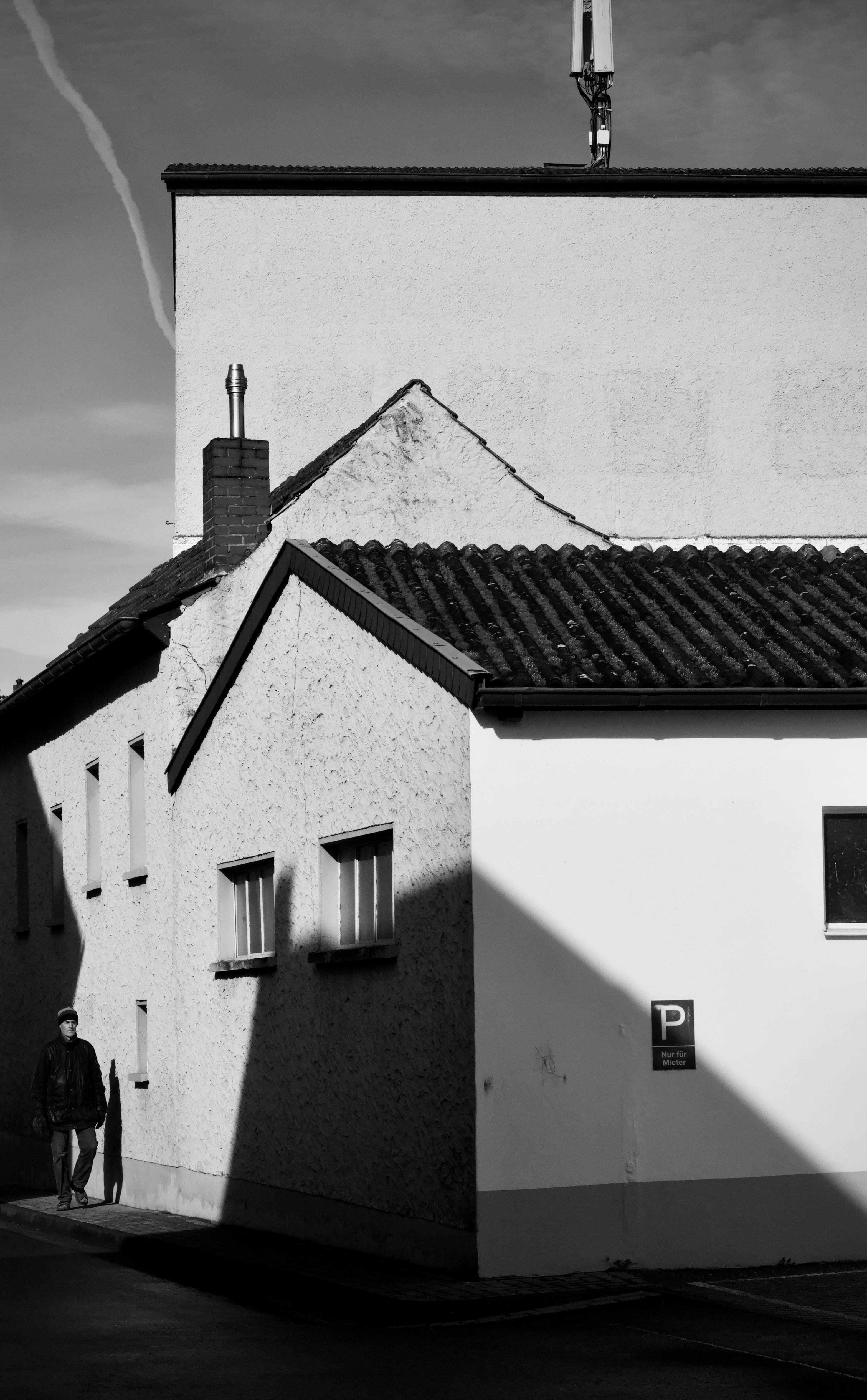 Gratis Fotografía en blanco y negro de una esquina de una calle urbana con sombras dramáticas y una figura solitaria. Foto de stock