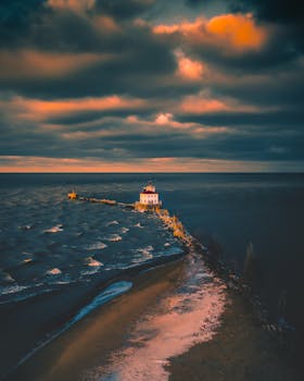 Stunning lighthouse overlooking the ocean at sunset with dramatic sky