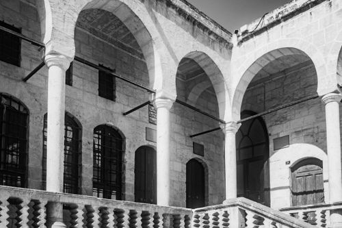 Free Capture of a historic stone building with arches in black and white. Stock Photo