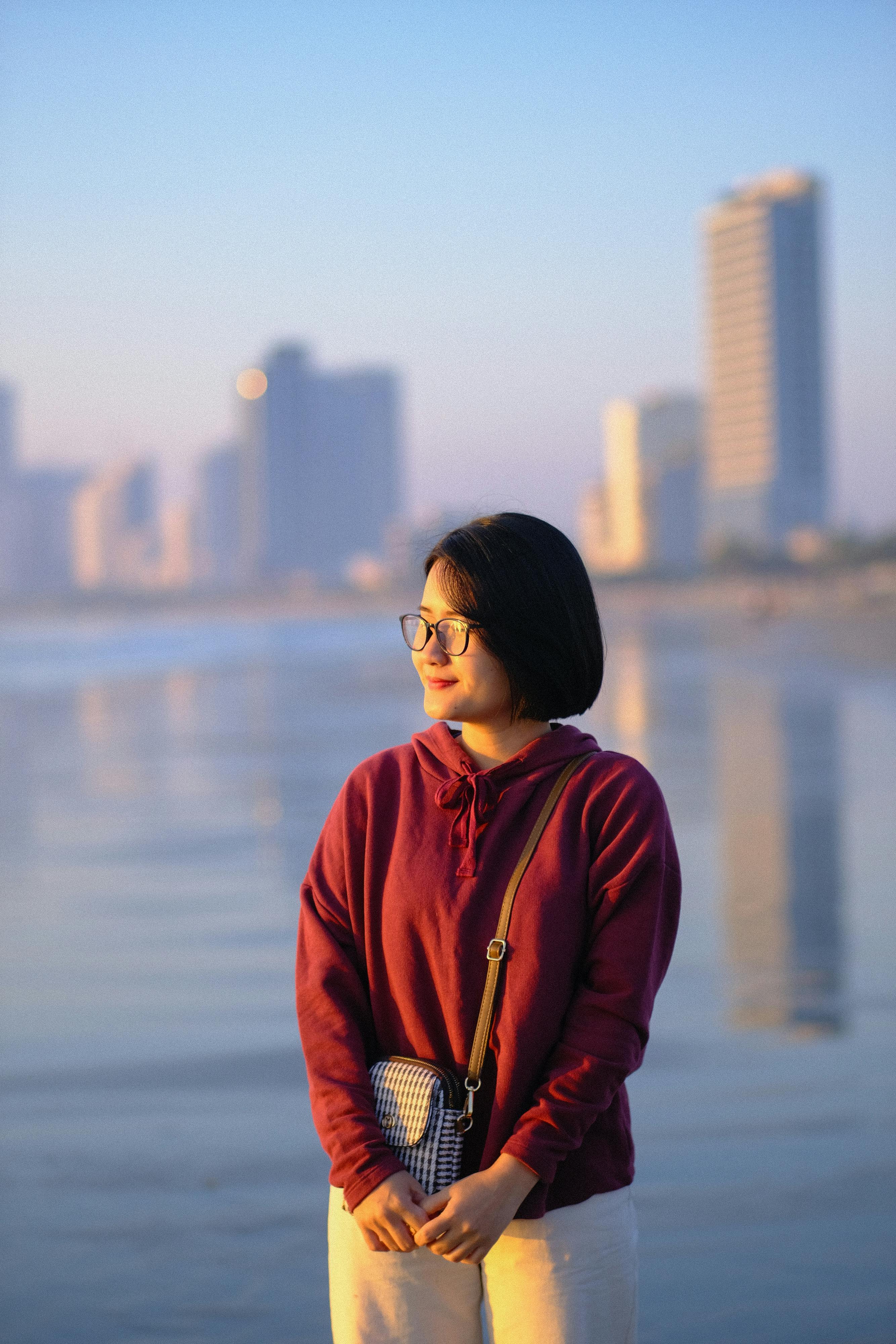 ฟรี หญิงสาวคนหนึ่งเพลิดเพลินกับพระอาทิตย์ขึ้นอันสงบสุขริมชายหาดในเมืองดานัง ประเทศเวียดนาม บันทึกช่วงเวลาแห่งความสงบสุขนี้ไว้ คลังภาพถ่าย