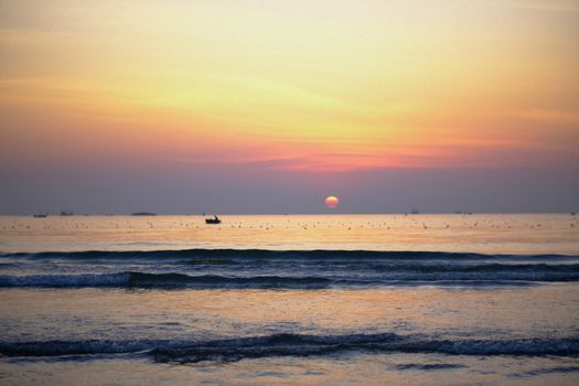 A breathtaking sunrise over the calm ocean waves at Đà Nẵng beach, Vietnam.