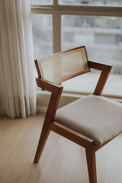 Mid-century wooden chair with a caned back and fabric seat — photo by Letícia Alvares on Pexels