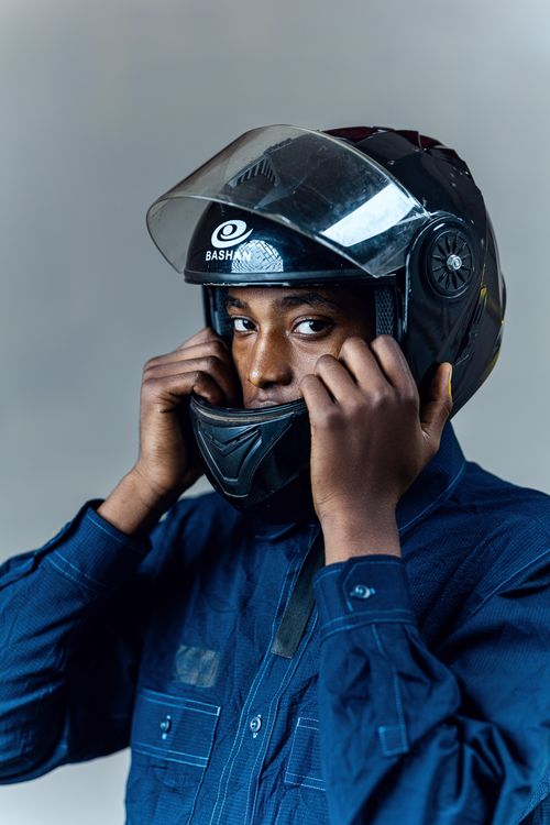 Free Man adjusting motorcycle helmet for safety. Indoor studio shot. Stock Photo