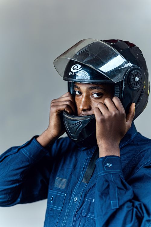 Free Young man adjusting a motorcycle helmet, ready for a ride. Stock Photo
