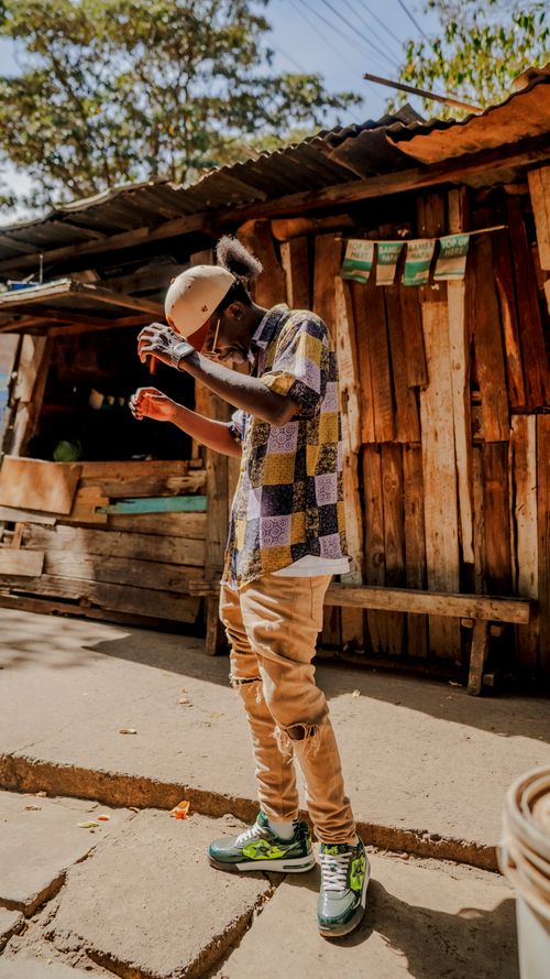 Free Stylish young man poses in Nairobi, embracing urban street fashion with a colorful flair. Stock Photo