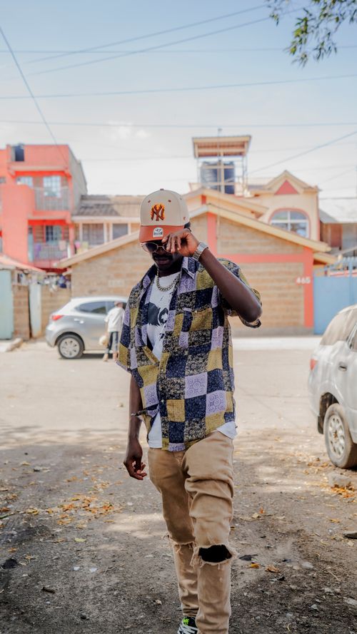 Free Casual street style portrait of a man in Nairobi with colorful architecture in the background. Stock Photo