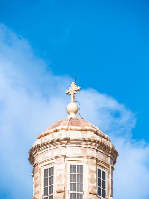 Free A classic church dome topped with a cross set against a vivid blue sky, symbolizing faith and heritage. Stock Photo