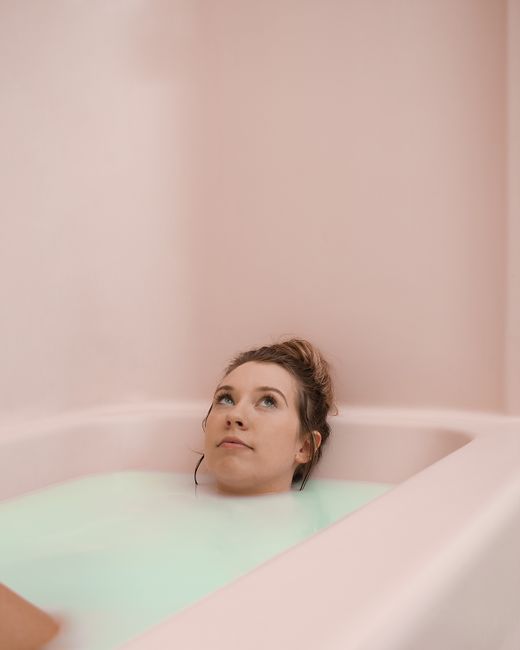 An adult woman enjoys a peaceful moment while relaxing in a soothing milk bath.