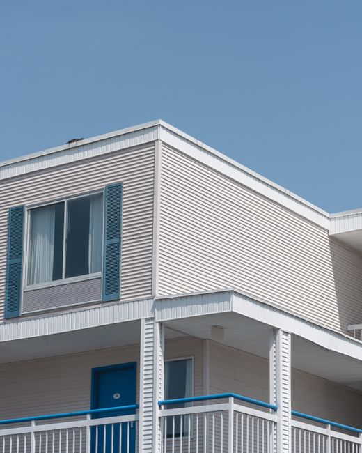 Minimalist exterior of a modern building with blue accents and clear sky background.