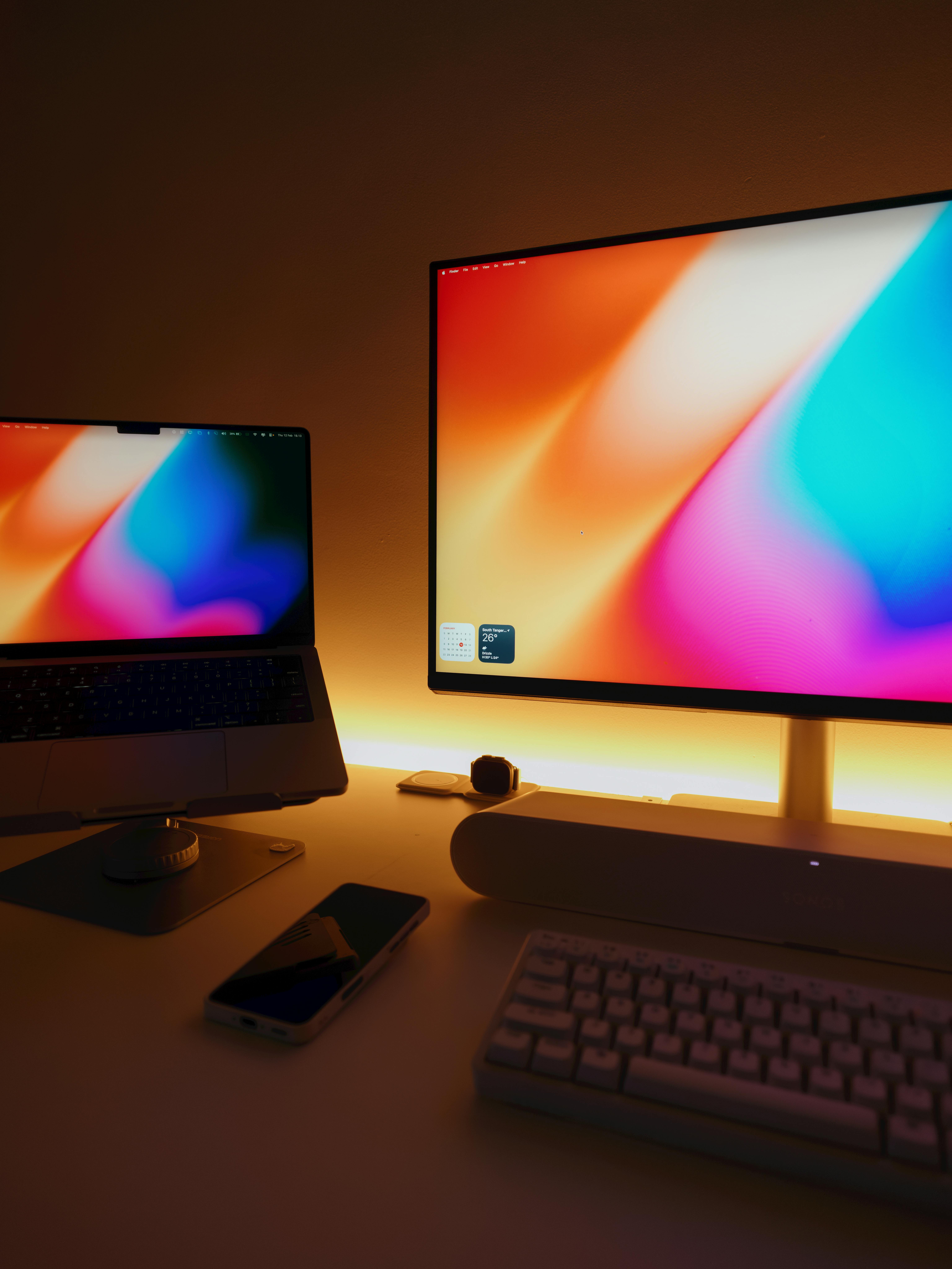 Gratis Una scrivania moderna ed elegante dotata di due monitor vivaci, tastiera e smartphone. Foto a disposizione