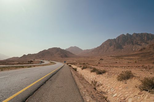 Free Wide road through desert landscape with mountains, Aqaba, Jordan, captured on a clear day. Stock Photo