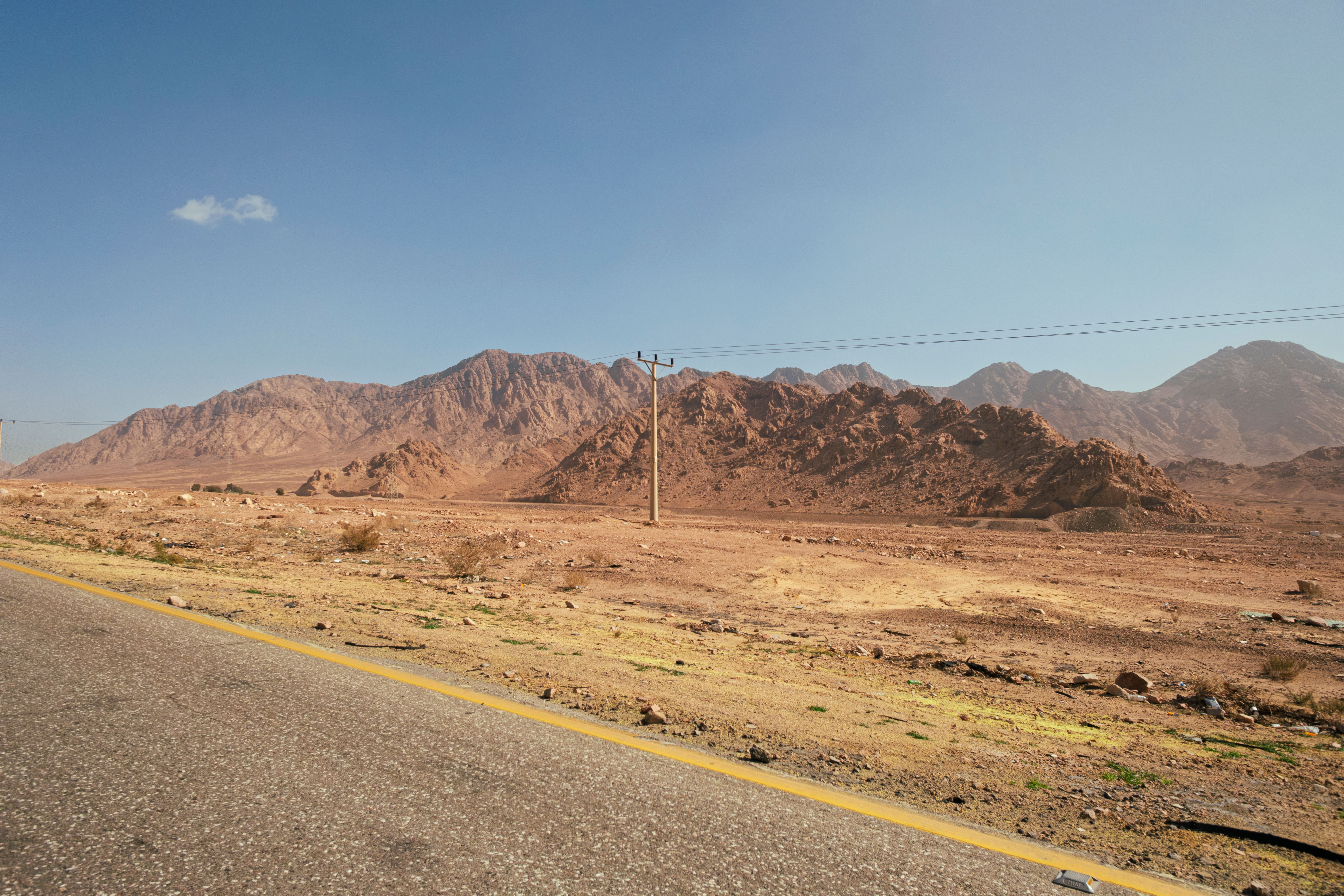 A car refueling at a modern gas station along the Desert Highway in Jordan.