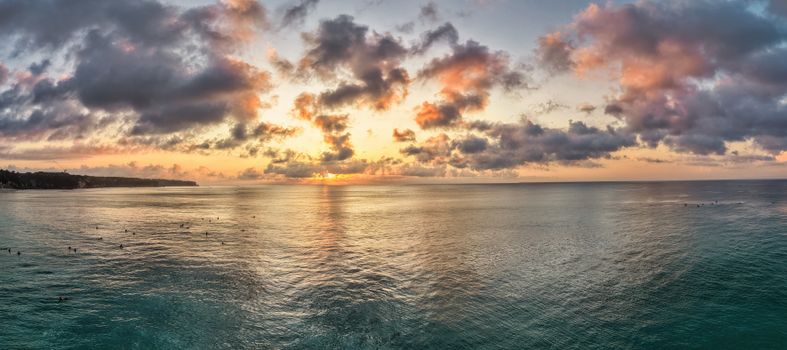 A stunning sunset view over the ocean in Bali, Indonesia, with vibrant clouds and tranquil waters.