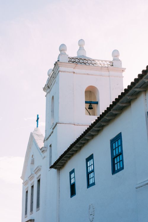 Free Elegant white church tower with blue accents under a clear sky, showcasing classic architecture. Stock Photo