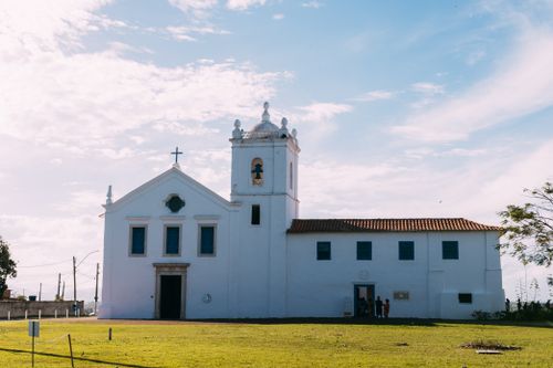 Free A historic white church building under a clear blue sky with a few people present. Stock Photo