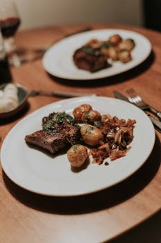 Tantalizing steak and herb potatoes on a beautifully set dinner table.