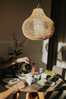 Warm indoor breakfast scene with coffee pouring and natural light.