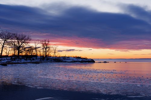 Free Serene winter sunrise over frozen Cove Island Park in Stamford, Connecticut, capturing icy reflections and colorful skies. Stock Photo