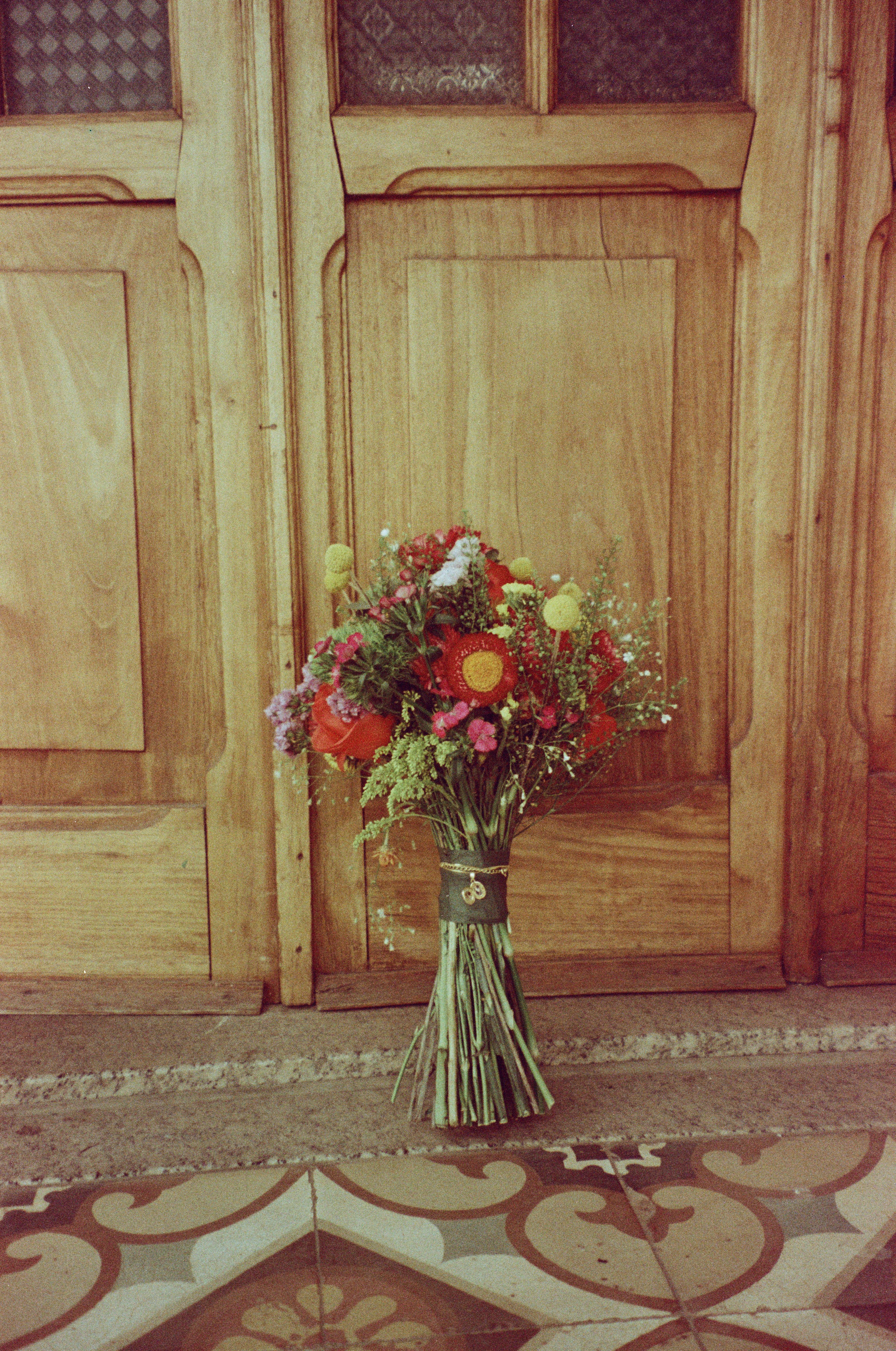 Gratuit Un buchet vibrant de flori pe uși rustice din lemn, într-un decor vintage. Fotografie de stoc