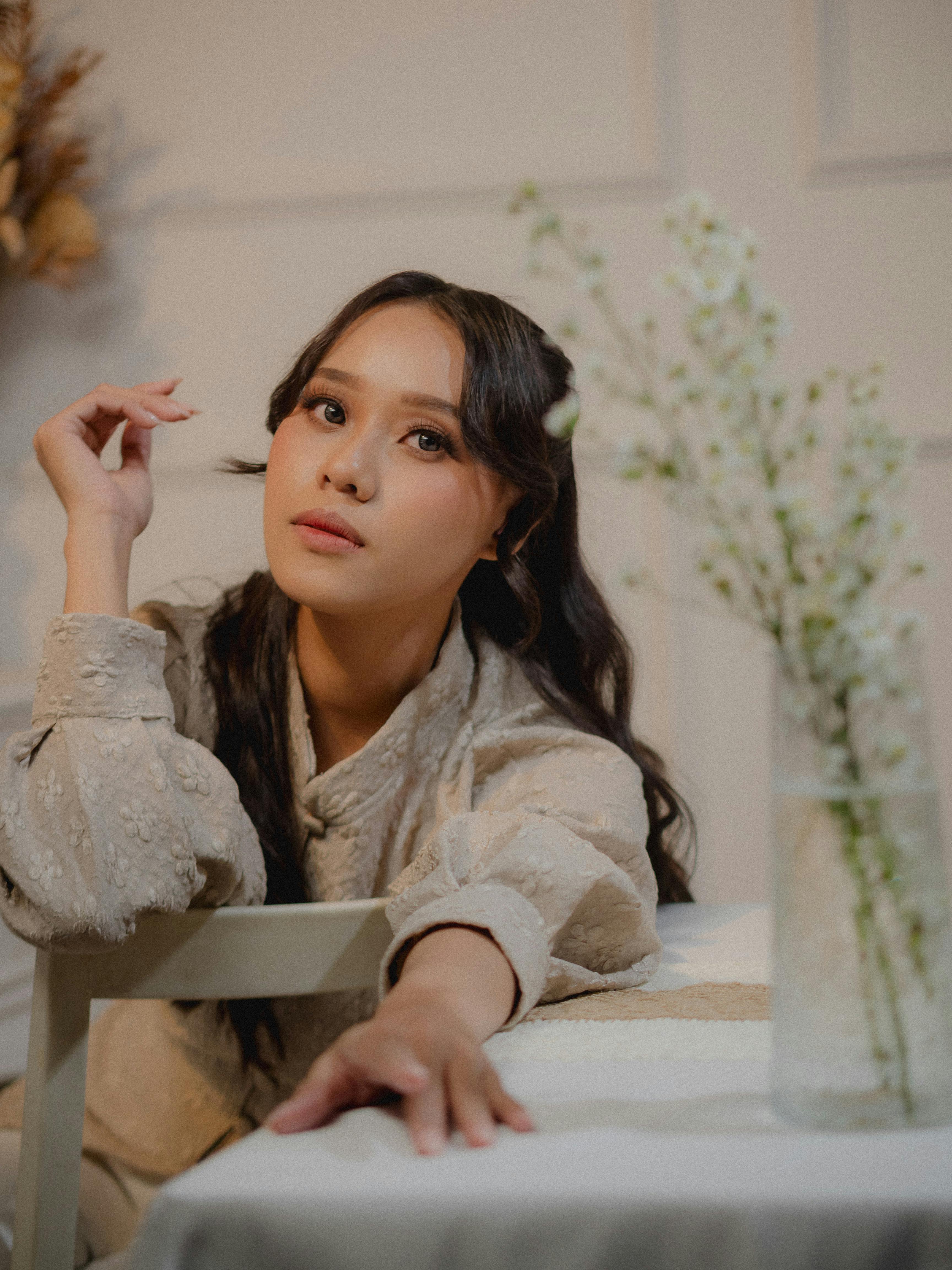 ฟรี ภาพถ่ายบุคคลหญิงในที่ร่มที่ดูสง่างาม โดยมีฉากหลังเบลอเล็กน้อย สื่อถึงอารมณ์ที่อบอุ่นและสงบสุข คลังภาพถ่าย