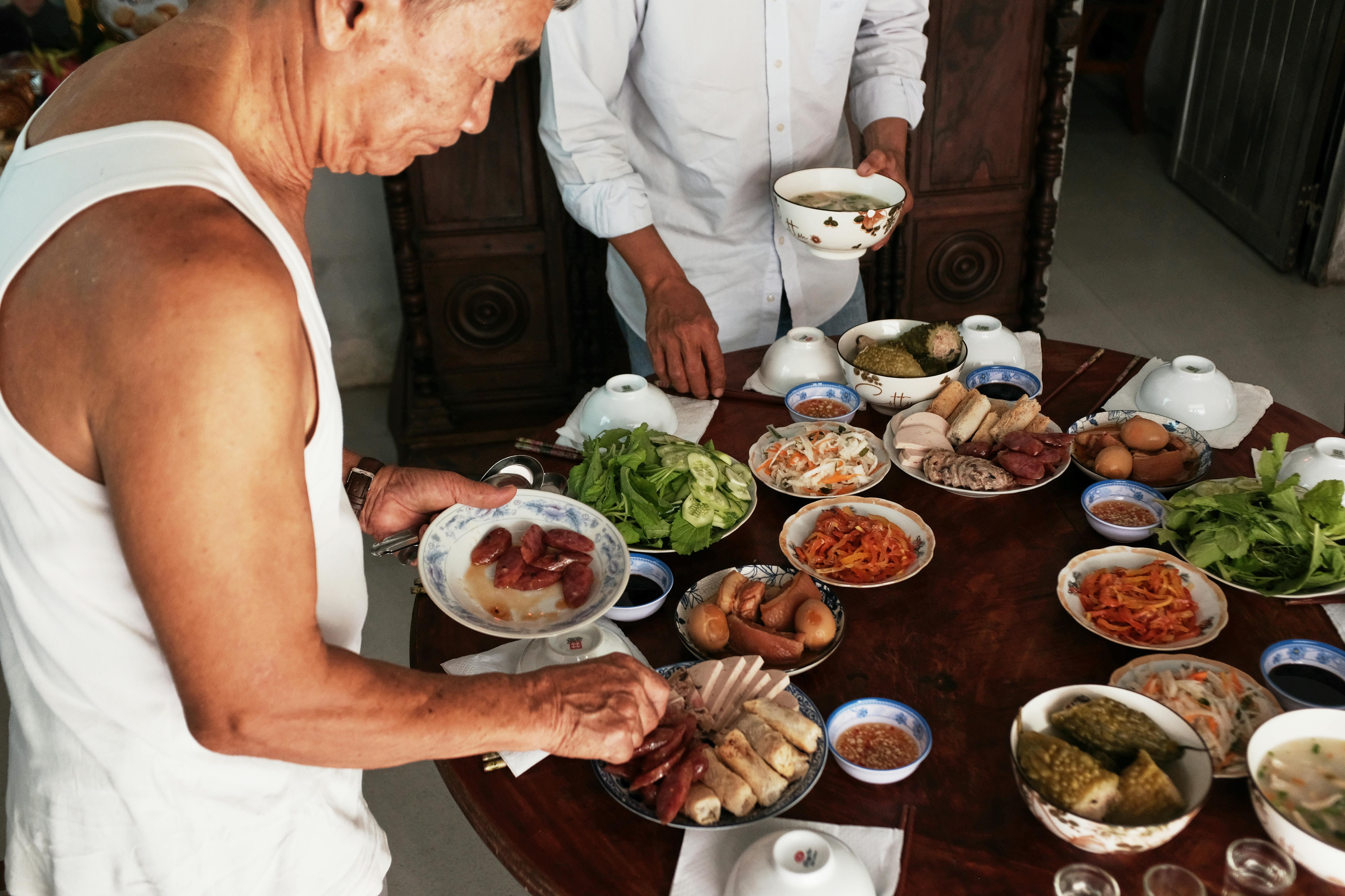 gratis Een levendig tafereel van de bereiding van traditionele Vietnamese gerechten voor een familiemaaltijd in Bến Tre, Vietnam. Stockfoto
