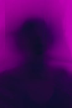 Artistic silhouette of a person blurred behind purple fabric, creating a mysterious effect.