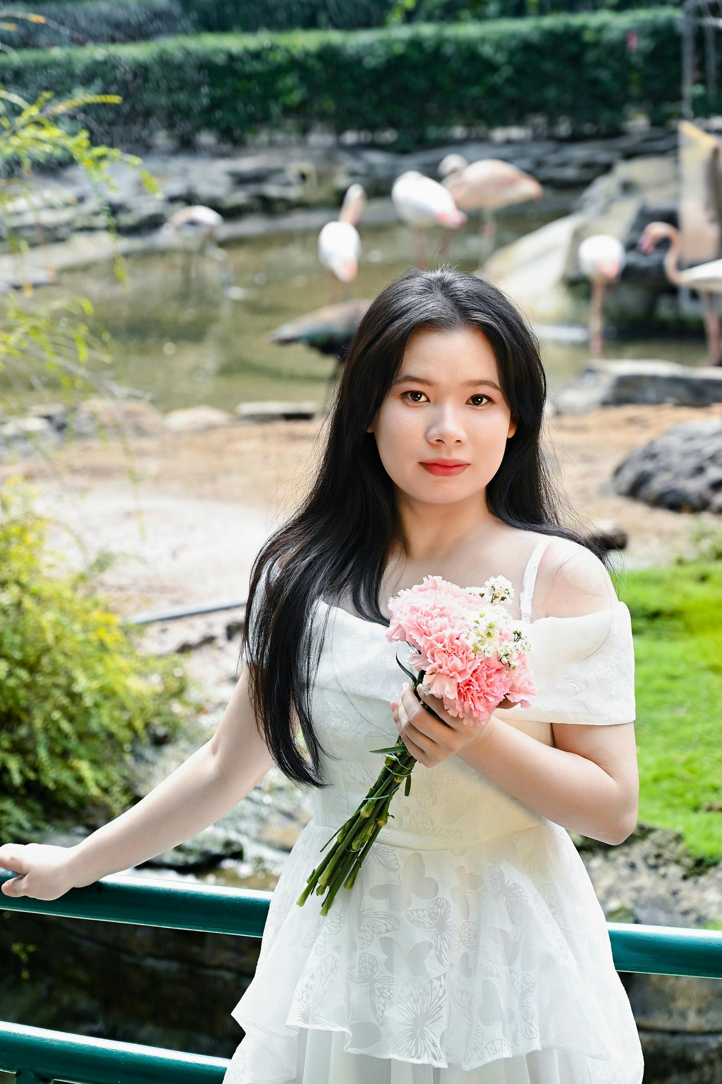 Wanita Dengan Bunga Merah Muda Di Lingkungan Taman Tropis · Foto Stok ...