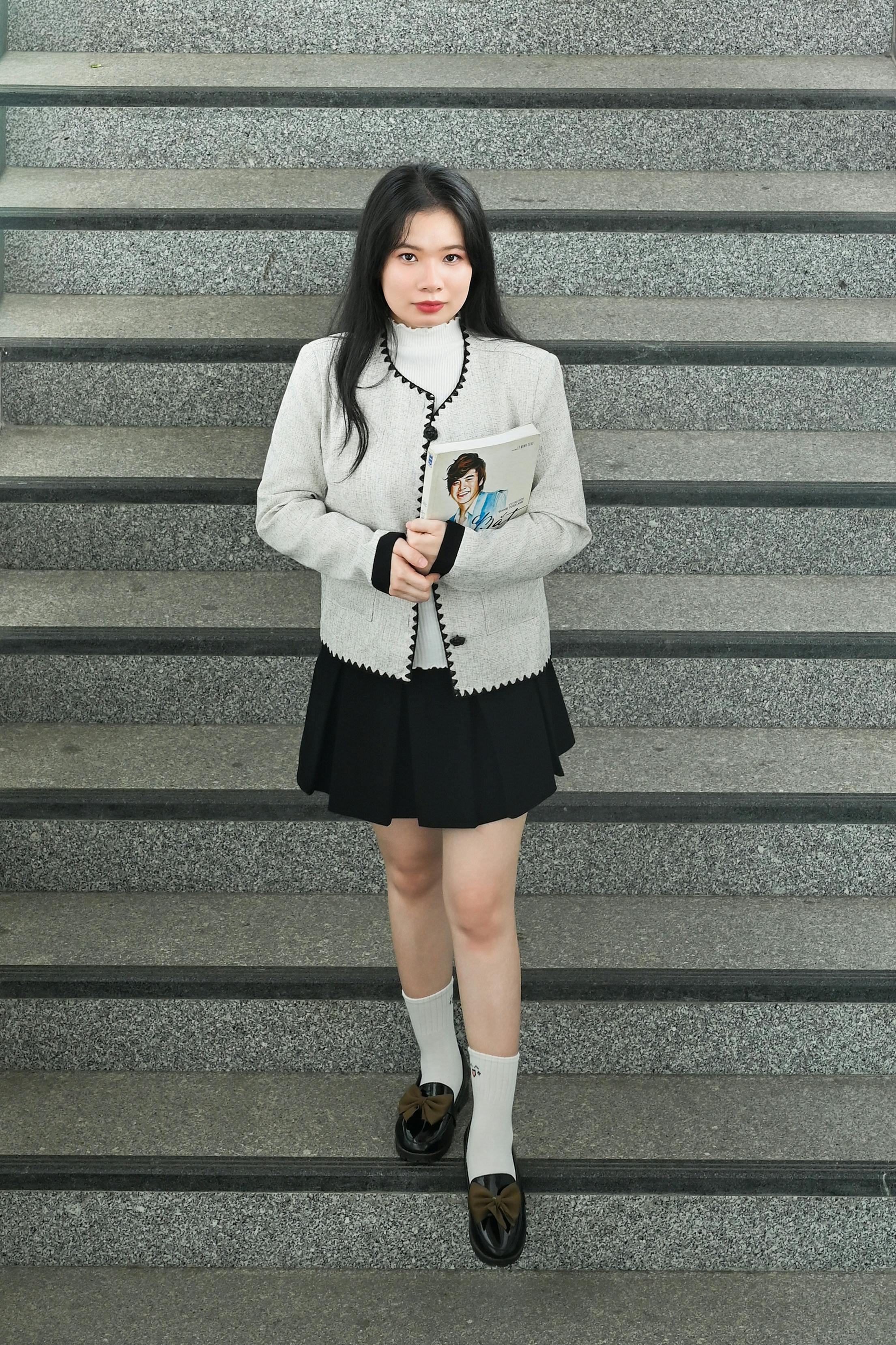 ฟรี หญิงสาวในชุดเครื่องแบบถือหนังสือ ยืนอยู่บนบันได คลังภาพถ่าย