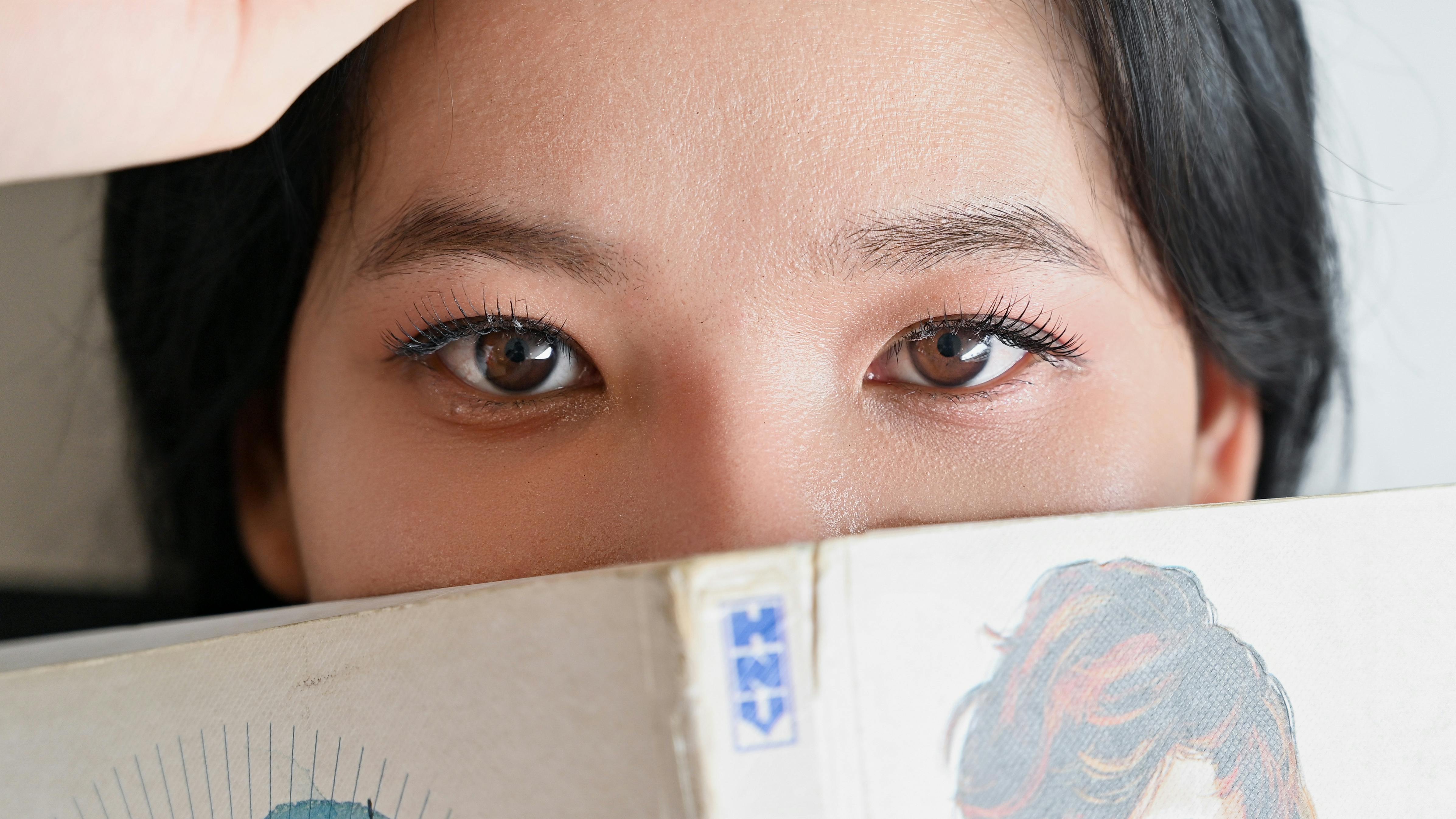 Gratis Primo piano degli occhi di una donna sopra un fumetto, che crea un'atmosfera misteriosa. Foto a disposizione