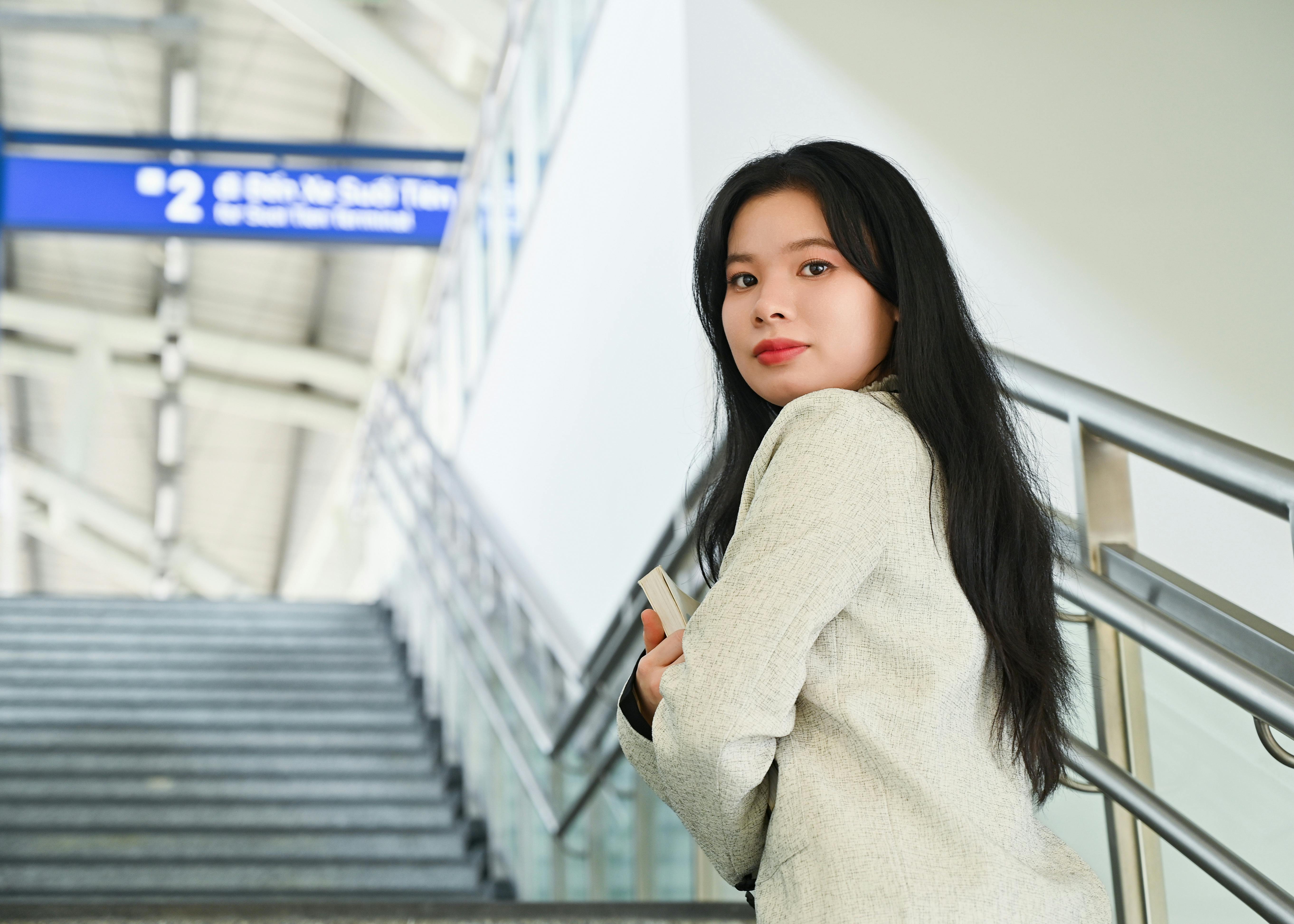 Gratis Giovane donna sicura di sé in piedi alla stazione ferroviaria, simbolo di ambizione professionale. Foto a disposizione