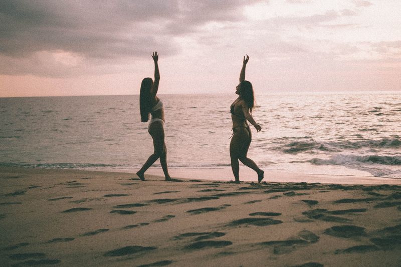 Two Women Enjoying a Scenic Beach Sunset · Free Stock Photo