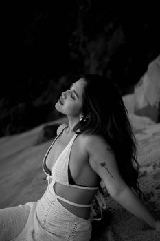 Captivating black and white portrait of a woman relaxing on a beach, conveying tranquility.