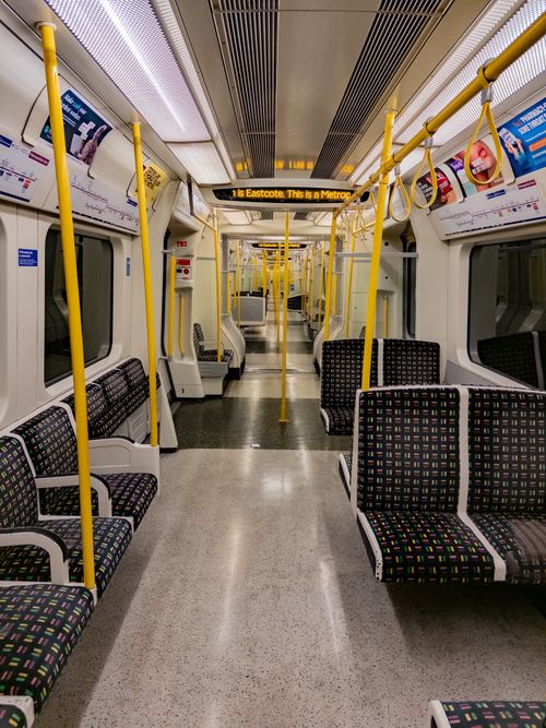 Free Interior of an empty London Underground train car at night, showcasing the Metropolitan line seating and design. Stock Photo