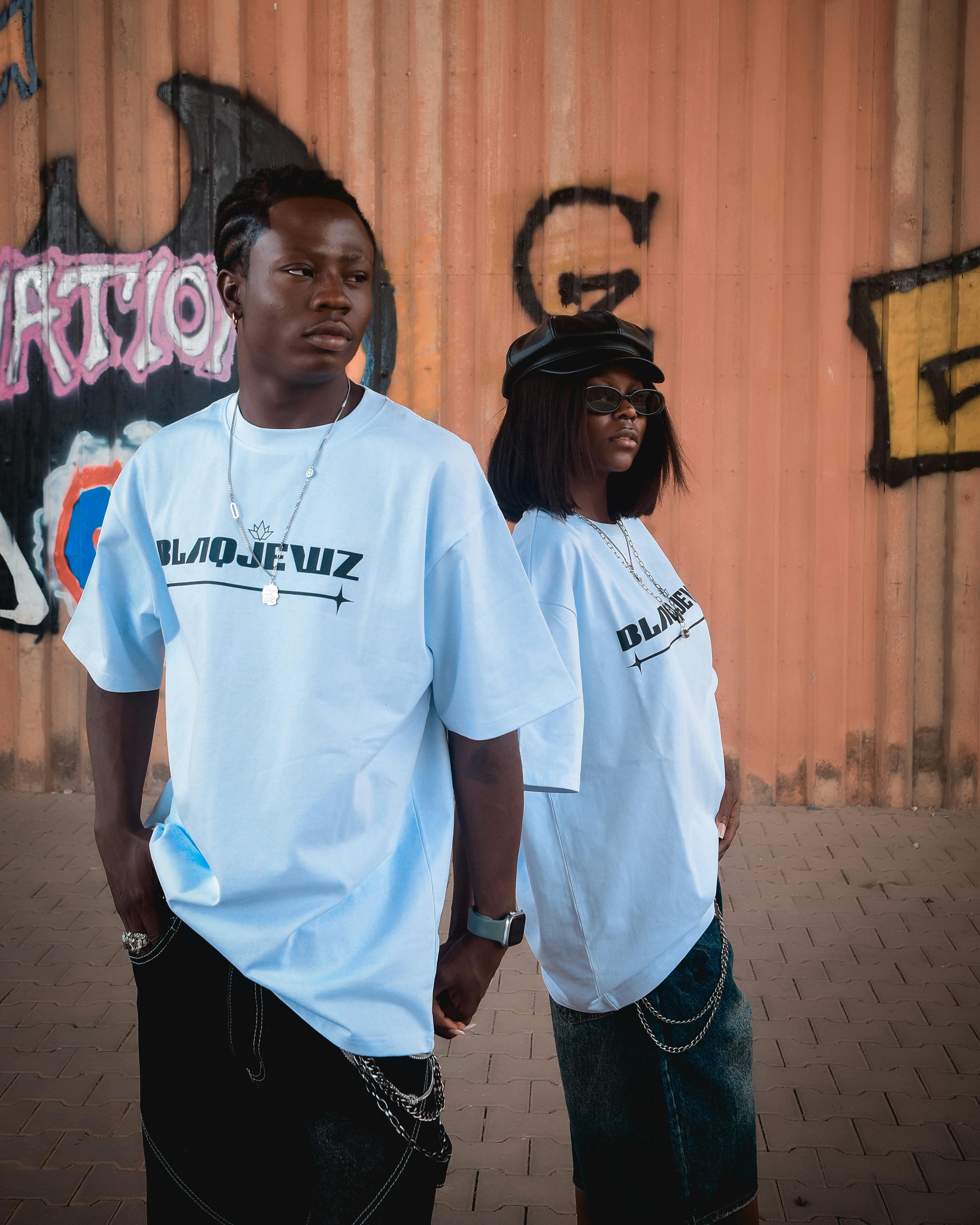 Urban Fashion Duo Posing Against Graffiti Wall