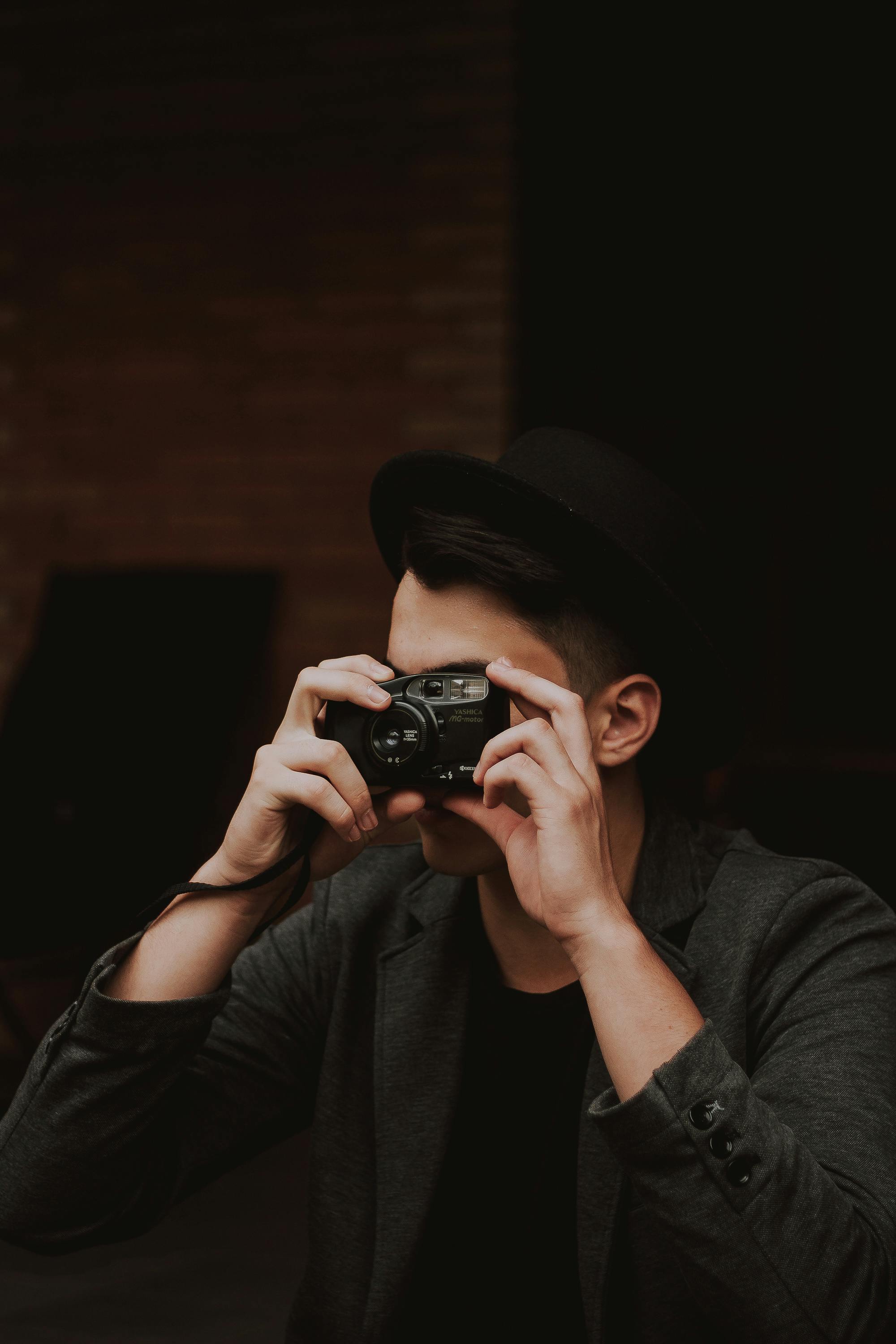 Gratis Pria Berbaju Hitam Memegang Kamera Hitam Foto Stok