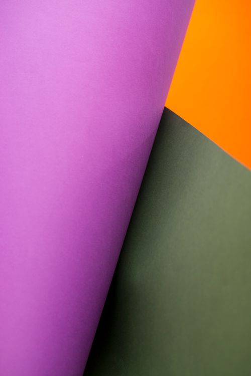 Free Vibrant abstract image featuring overlapping sheets of purple, green, and orange paper. Stock Photo