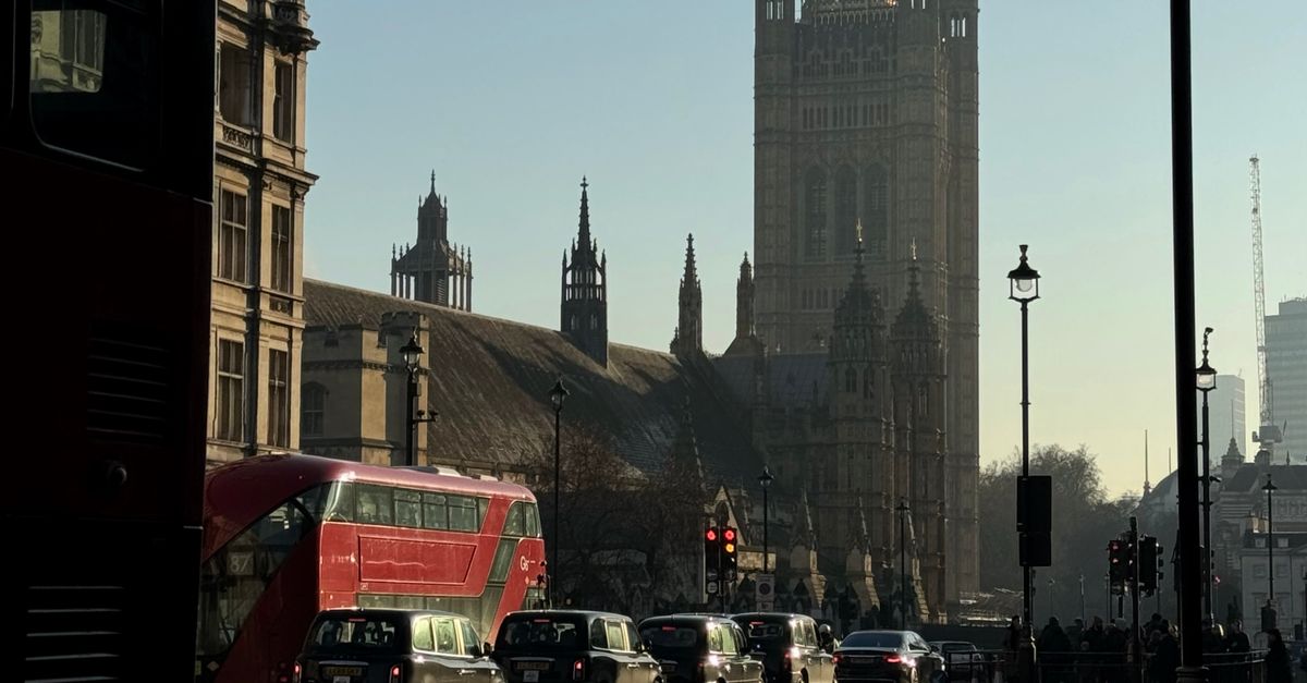 Iconic view of Westminster Palace in London with classic red double-decker bus.