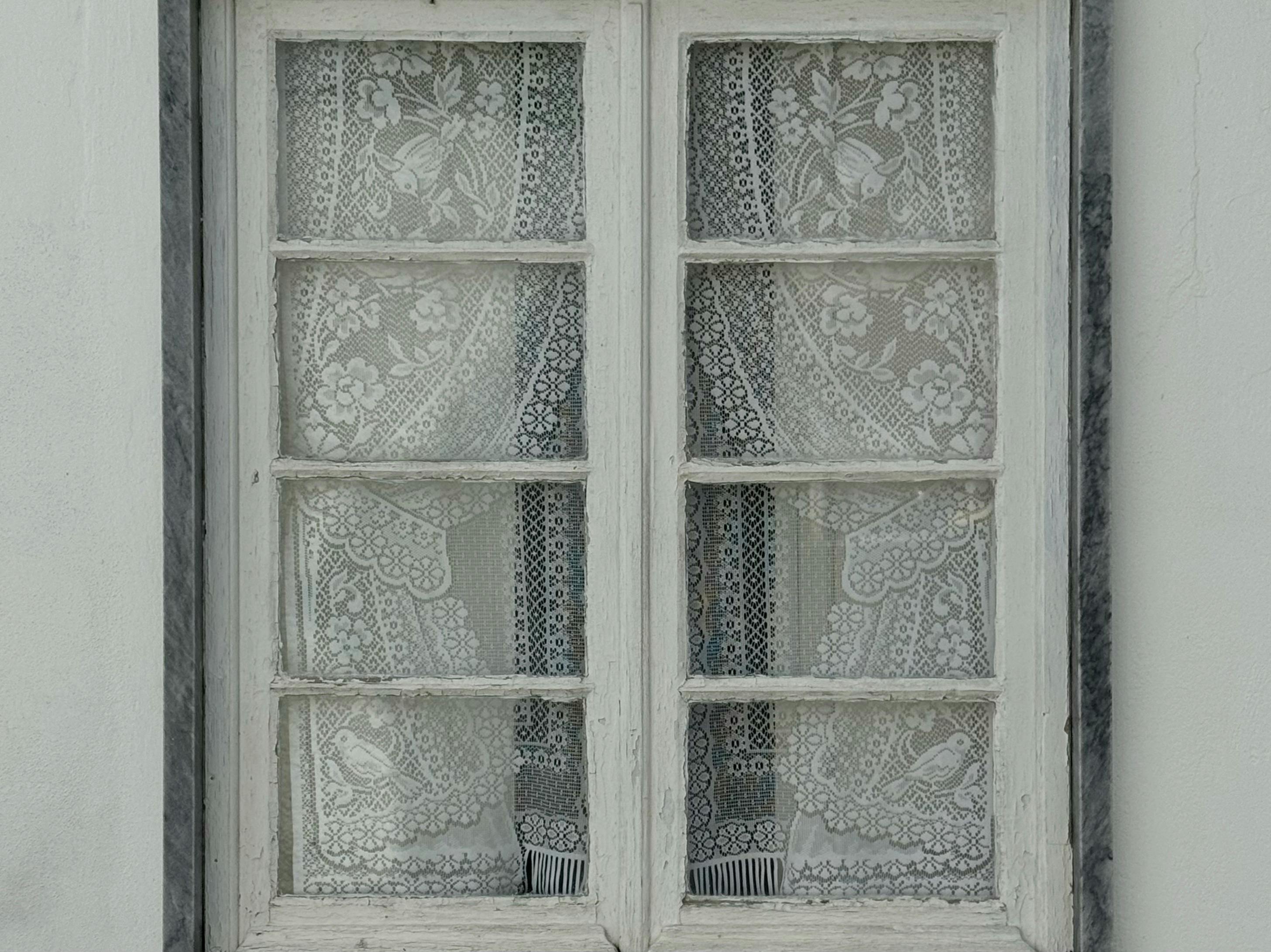 Ücretsiz Dekoratif dantel perdeleriyle süslenmiş, detaylı çiçek desenleriyle rustik bir estetik sunan zarif vintage pencere. Stok Fotoğraflar