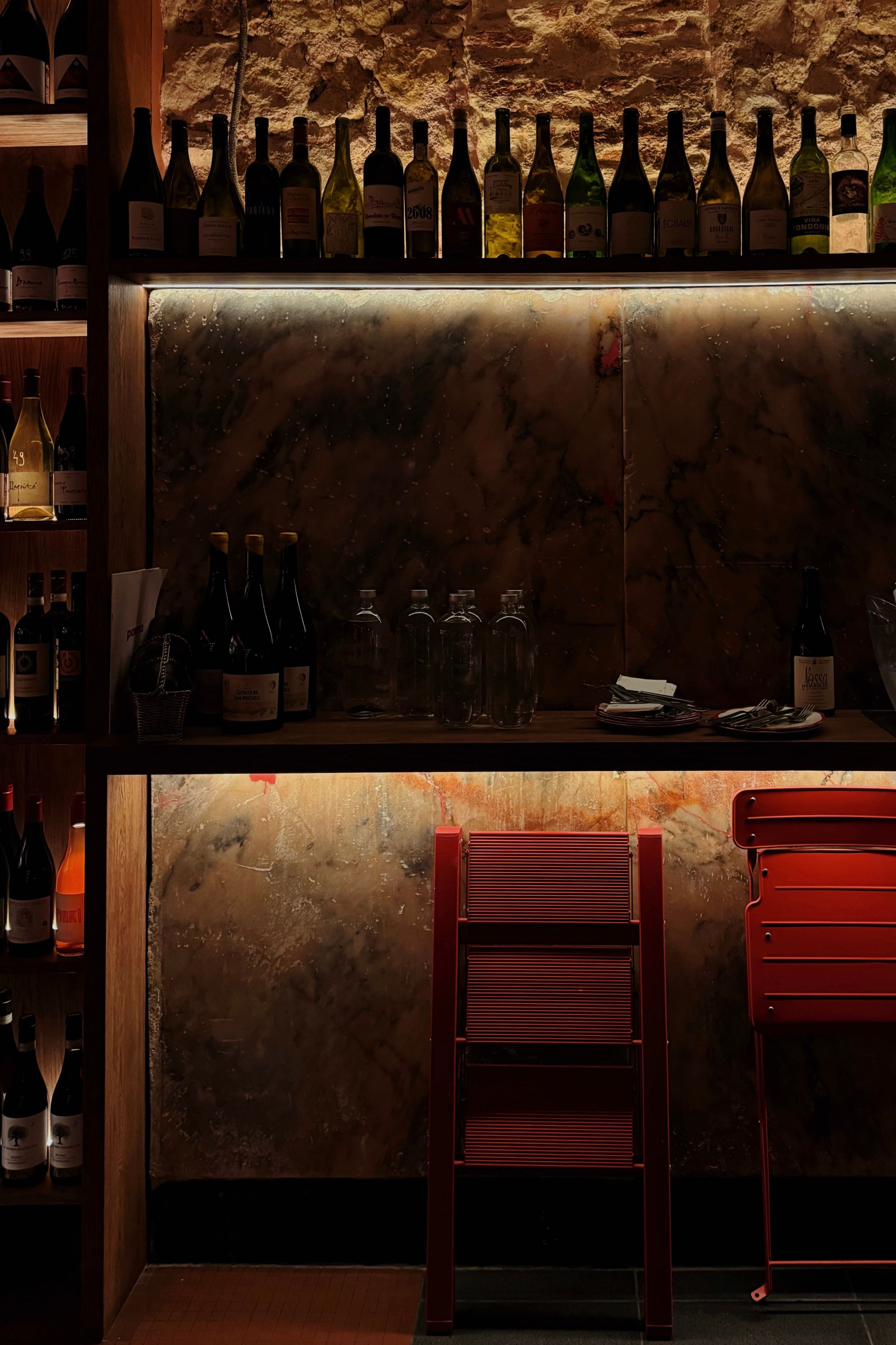 Inviting wine bar with an array of wine bottles and dim lighting for a warm ambiance.