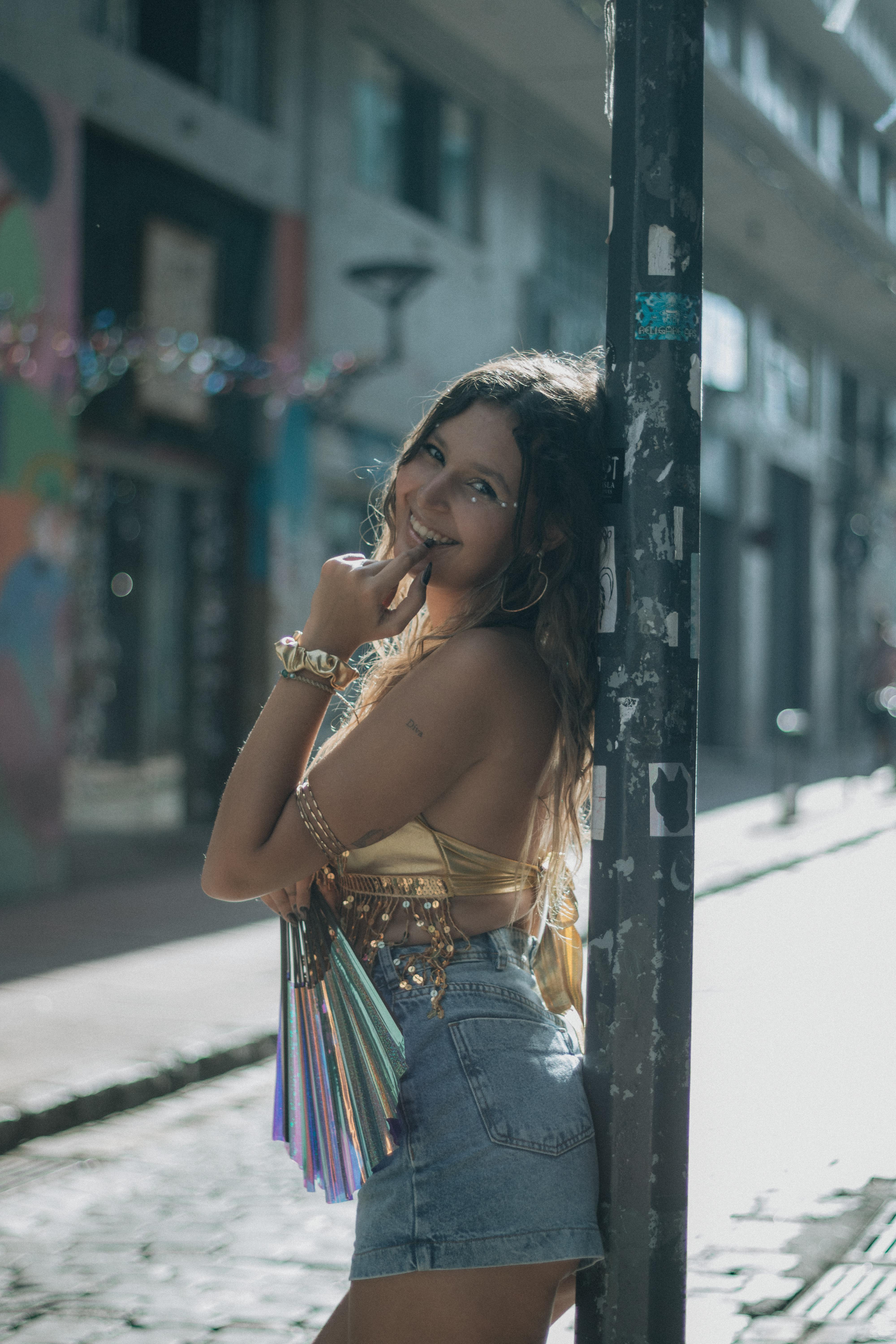 Zadarmo Mladá žena v módnom oblečení pózuje vonku na slnečnej mestskej ulici. Fotka z fotobanky