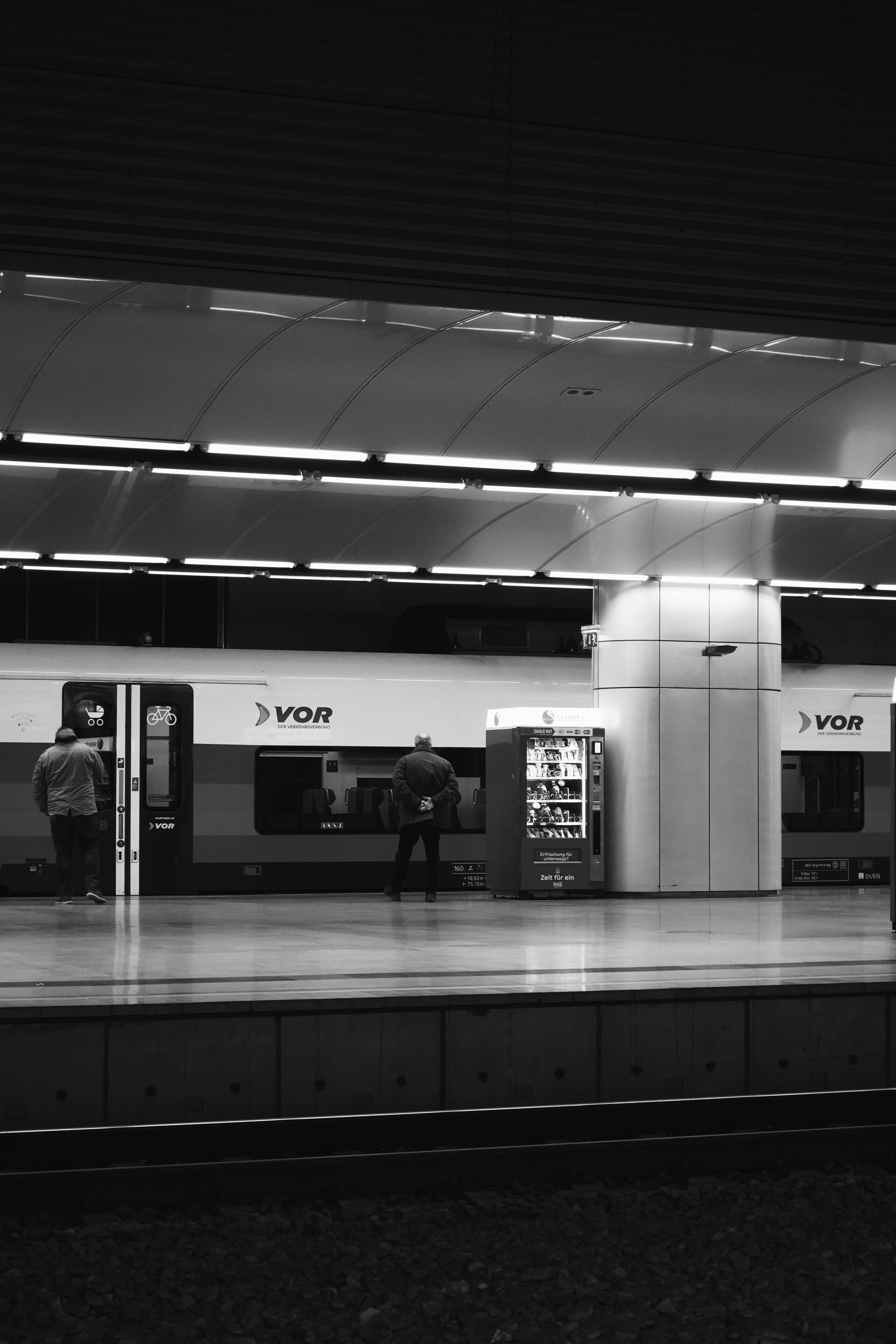 Gratis Imagen monocromática de la estación de tren de Viena que muestra un tren y viajeros. Foto de stock