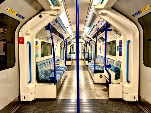 Free A well-lit empty London Tube carriage showing its iconic seating and handrails. Stock Photo