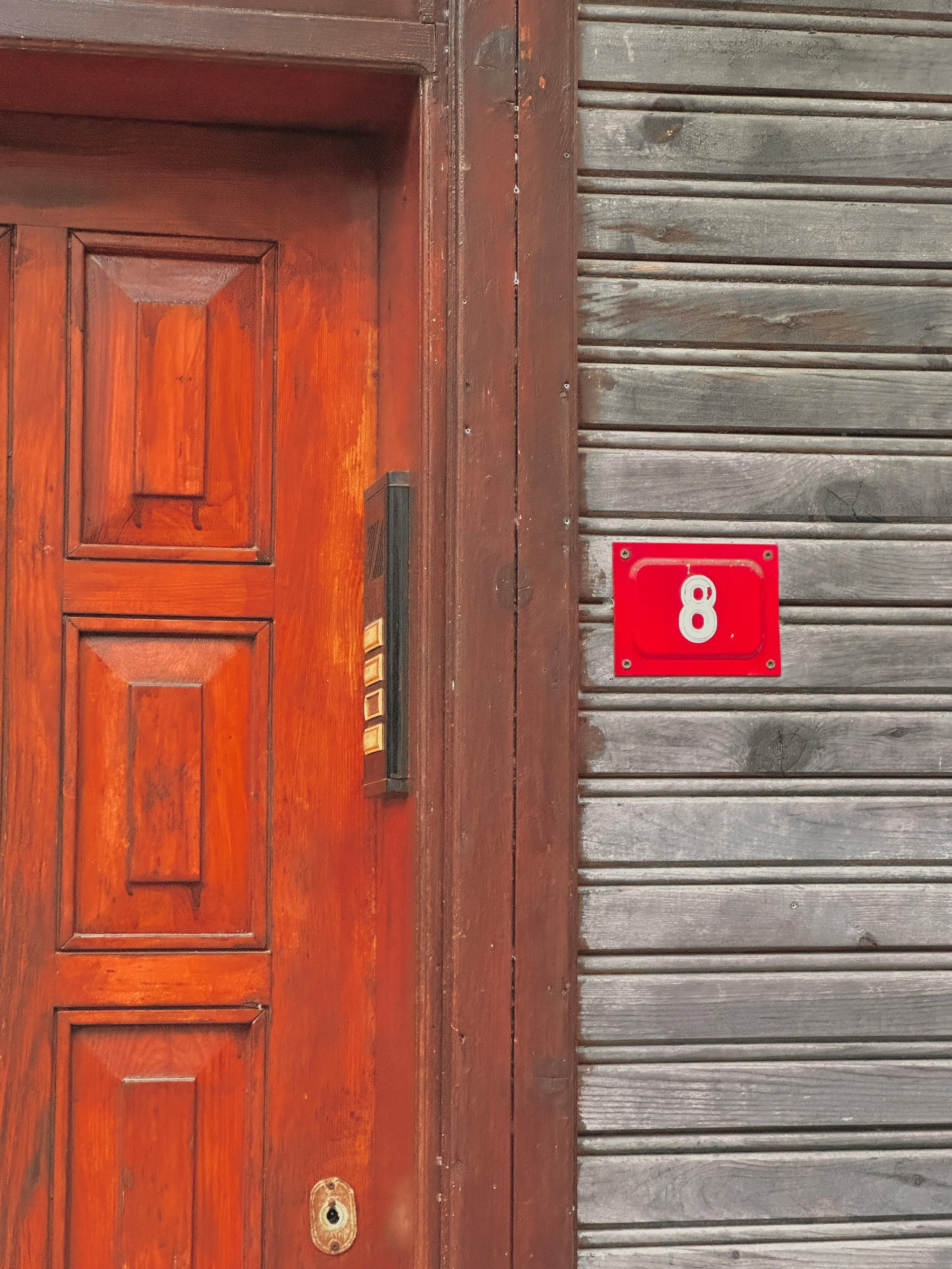 Free Rustic wooden door with a vibrant red number 8 sign in Istanbul's historic neighborhood. Stock Photo