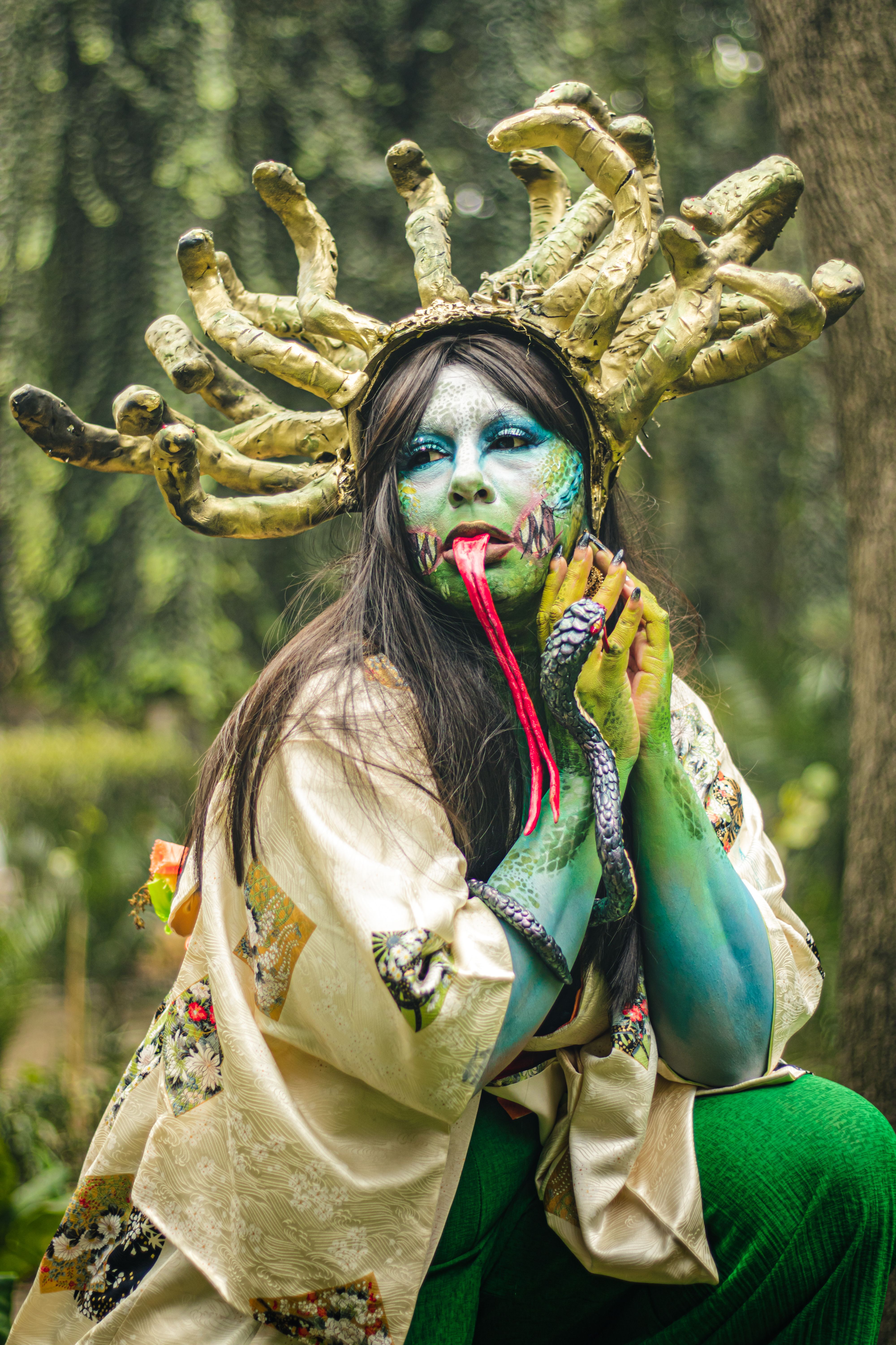 Artistic cosplay with intricate makeup and costume in a natural environment, exuding fantasy vibes.