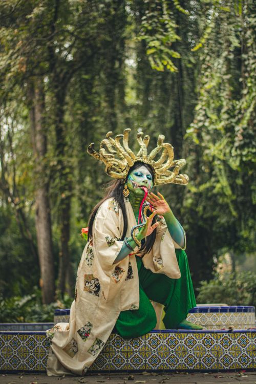 Free A vivid cosplay of a mythical creature with artistic makeup, set outdoors in a Mexican garden. Stock Photo