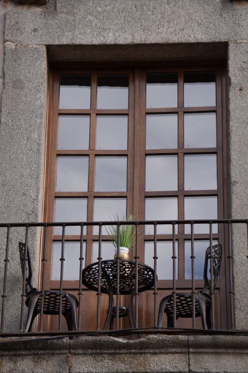 Free Elegant stone balcony with iron furniture and potted plant, reflecting classic architecture style. Stock Photo